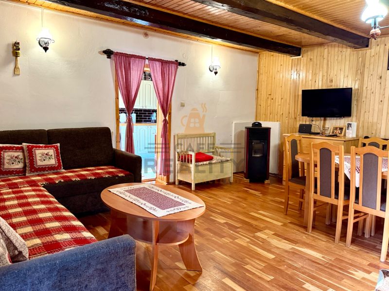 Wohnzimmer mit Kamin, Fernseher und Holzboden in einem Einfamilienhaus.