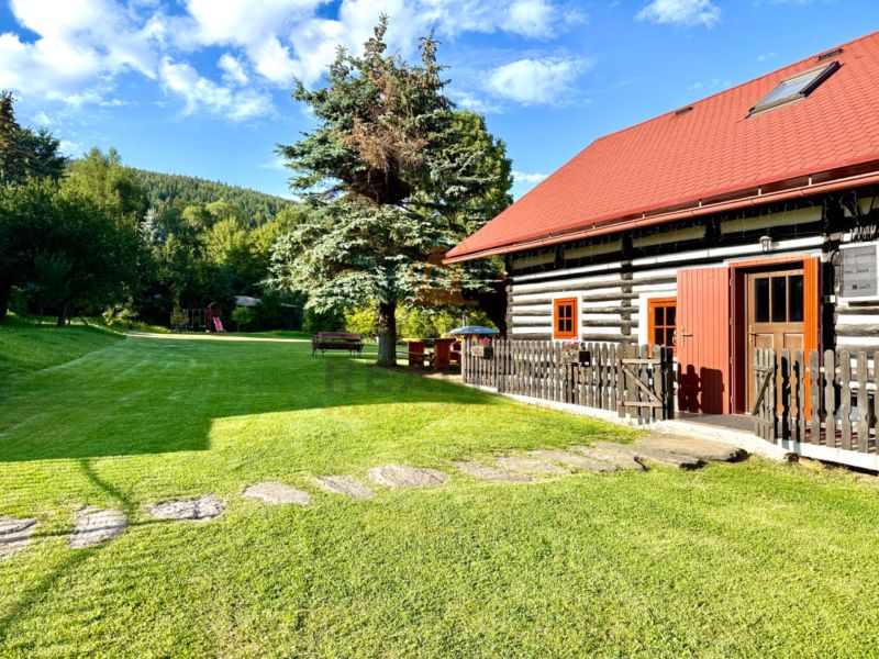 Ein Einfamilienhaus in der Jána Švermu Straße in Šumiac mit einem Holzzaun und einem grünen Hof.