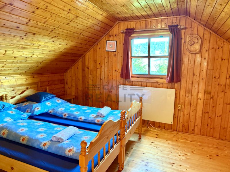 Innenraum aus Holz mit Holzboden und zwei Betten in einem Einfamilienhaus.