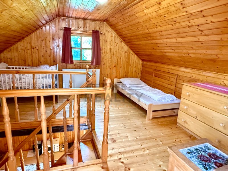 Das Dachgeschoss eines Einfamilienhauses mit Holzverkleidung und einem Boden in Holzoptik.