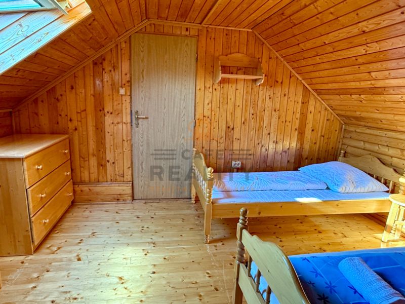 Ein Dachzimmer in einem Einfamilienhaus mit Holzelementen und einfacher Einrichtung.