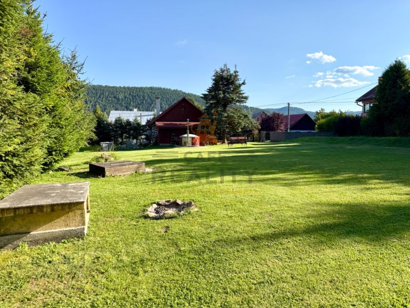 Garten bei einem Einfamilienhaus in der Straße Jána Švermu in Šumiac mit Rasen und Feuerstelle.