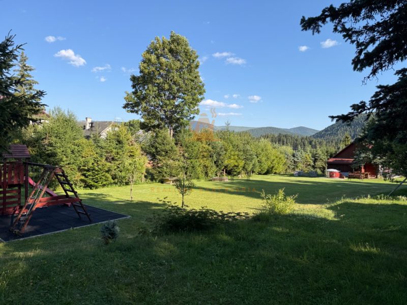 Einfamilienhaus in Šumiac in der Straße Jána Švermu, Rasenfläche mit Spielplatz umgeben von Natur.