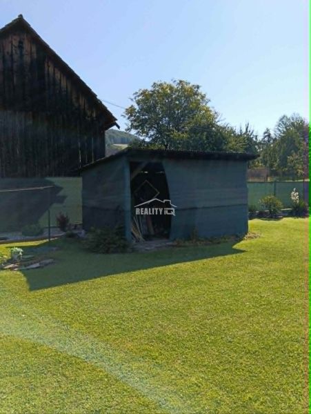 Ein Garten mit einer Holzhütte und Rasenbewuchs in Ovčiarsko, geeignet für Wohnbaugrundstücke.