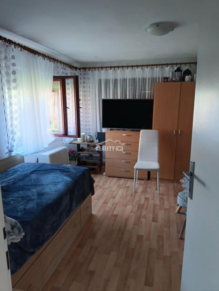 Zimmer mit Fernseher, Bett und Holzboden, Grundstücke - Wohnen.