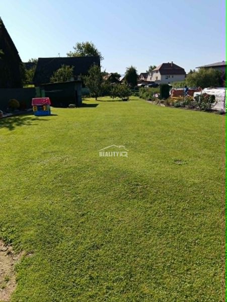 Ein ebener Rasen auf einem Grundstück zum Wohnen in Ovčiarsko mit umliegenden Häusern auf dem Land.