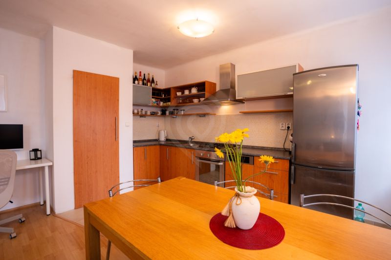 Küche in einer 4-Zimmer-Wohnung mit Holzdekor und gelbem Blumenzubehör.