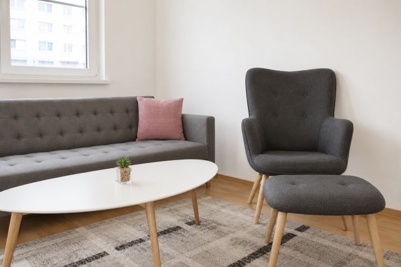 Wohnzimmer mit einem bequemen Sofa und einem Sessel in einer 2-Zimmer-Wohnung.