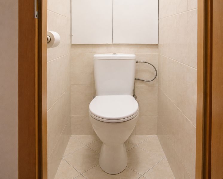 Badezimmer in einer 2-Zimmer-Wohnung mit beigen Fliesen und Toilette.