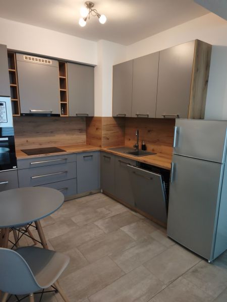 Stilvolle moderne Küche mit Holzboden in einer Einzimmerwohnung.
