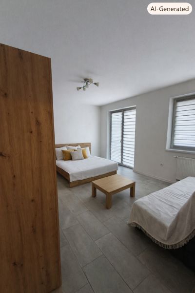Ein Zimmer mit einem Bett, einem Tisch und einem Boden mit Holzdekor in einer Einzimmerwohnung.