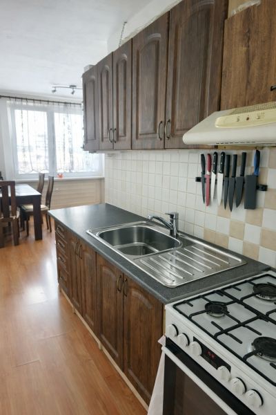 Küche in einer 3-Zimmer-Wohnung mit Holzboden und stilvollen Schränken.