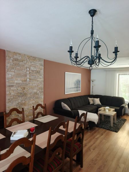 Wohnzimmer in einem Einfamilienhaus mit Sofa, Esstisch und Holzboden.