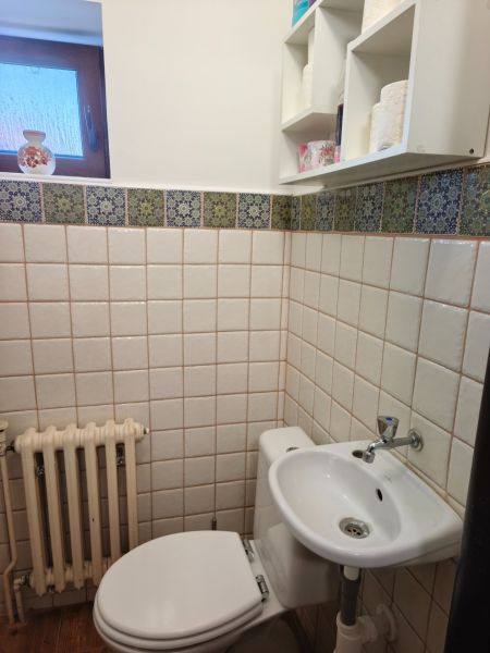 Badezimmer in einem Einfamilienhaus mit Toilette, Waschbecken und Fenster, gefliest.