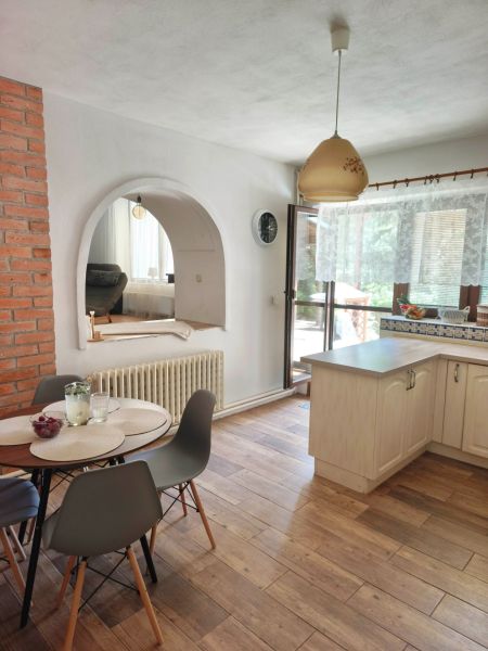 Esszimmer in einem Einfamilienhaus mit einem gewölbten Durchgang und einem Boden in Holzoptik.