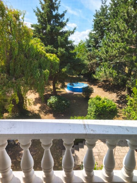 Blick aus dem Einfamilienhaus in Mankovce auf den grünen Garten mit Pool.