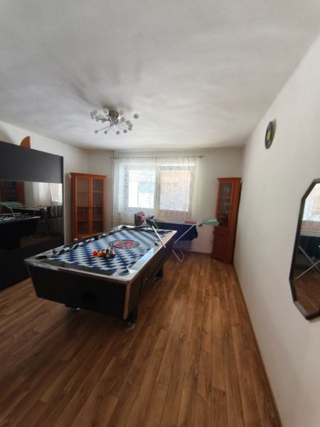 Einfamilienhaus mit Billardtisch, Boden in Holzoptik und lichtdurchflutetem Raum.