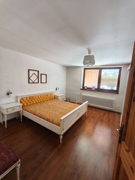 Schlafzimmer mit Bett und Holzboden in einem Einfamilienhaus.
