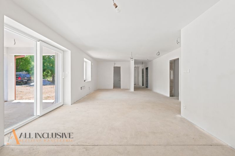 Ein luftiges Interieur mit weißen Wänden und großen Fenstern in einem Einfamilienhaus.