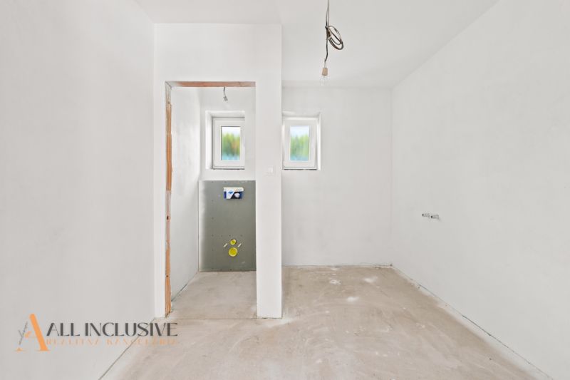 Das Innere eines Einfamilienhauses mit verputzten Wänden und vorbereiteten Anschlüssen für Installationen.