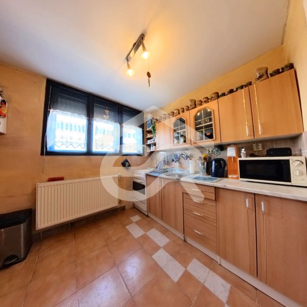 Küche mit braunen Schränken und einem geräumigen Fenster in einem Einfamilienhaus.