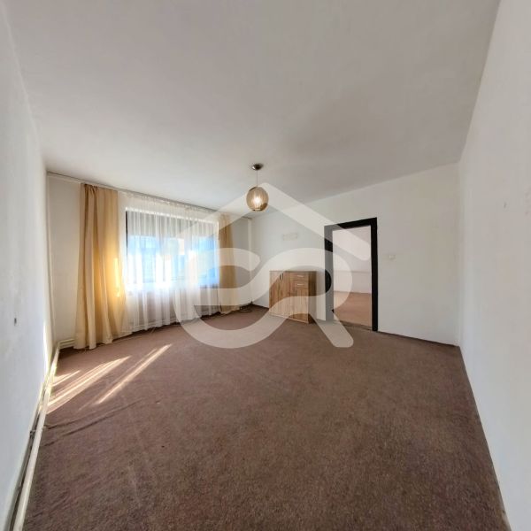 Wohnzimmer in einem Einfamilienhaus mit Teppichboden, Vorhängen und Licht.
