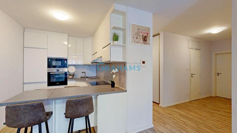 Küche mit Bartresen und Holzboden in einer 3-Zimmer-Wohnung.