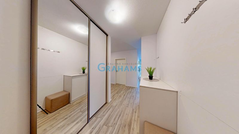 Flur einer 3-Zimmer-Wohnung mit Schrank und Boden in Holzoptik.