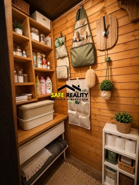 Gemütliche Kammer in der Blockhütte mit praktischen Regalen, einem Organizer und dekorativen Pflanzen.