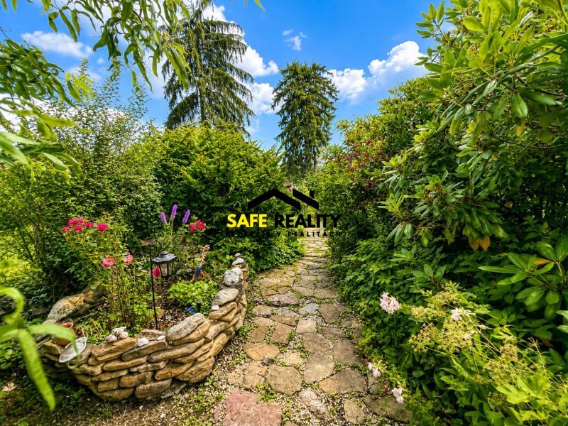 Ein Garten bei der Hütte in Žilina mit einem Steinweg und einem Blumenbeet.