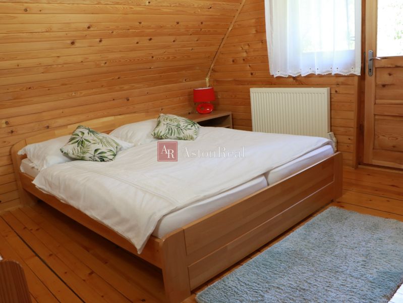 Ein Schlafzimmer in einer Hütte mit Holzverkleidung, einem Bett und einem Boden mit Holzdekor.