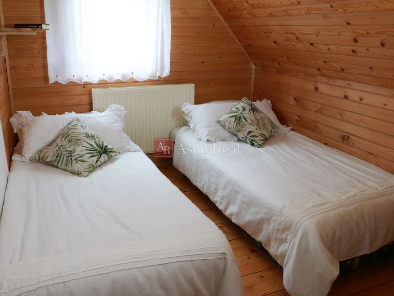 Ein Schlafzimmer in einer Hütte mit Holzverkleidung, zwei Betten und dekorativen Kissen.