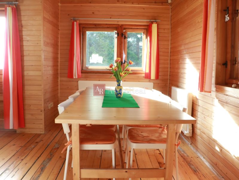 Holzverkleidung, Tisch mit Blumen, Boden mit Holzdekor und bunte Vorhänge, Hütte.