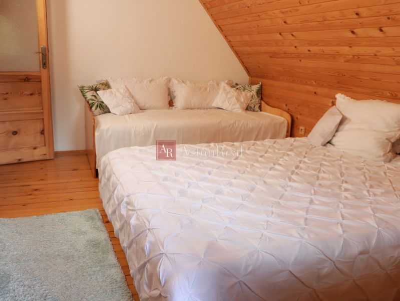 Ein Schlafzimmer in einer Hütte mit zwei Betten, einem Dachboden und einem Boden mit Holzdekor.
