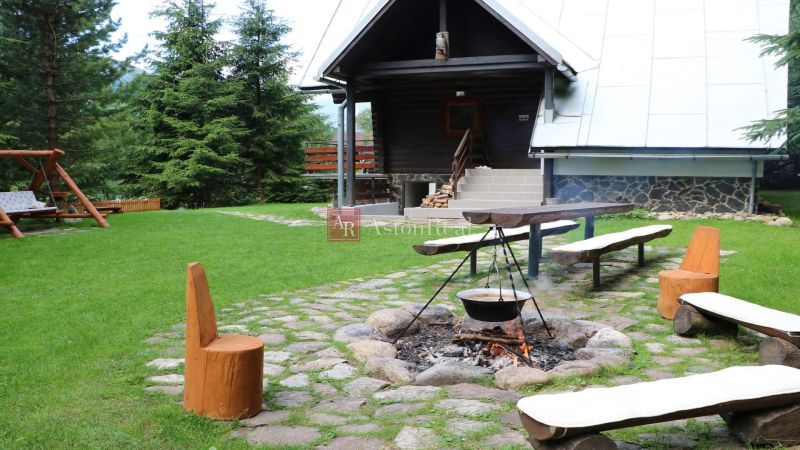 Blockhütte in Tále in Brezno mit Feuerstelle und Holzbänken im Rahmen von Hotels und Pensionen.