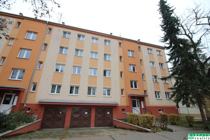 Wohnhaus in Trnava mit bunter Fassade, Garagen und Umgebung mit Bäumen.