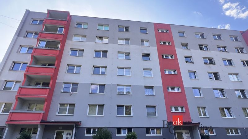 Ein sechsstöckiges Wohnhaus in Utekáč mit Balkonen und farbigen Teilen der Fassade.