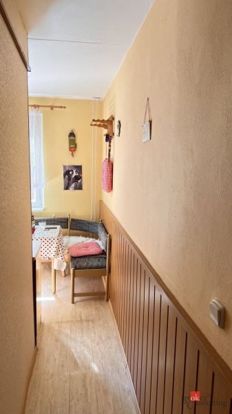 Gemütliche Ecke in einer 2-Zimmer-Wohnung mit Holzboden und bunten Dekorationen.