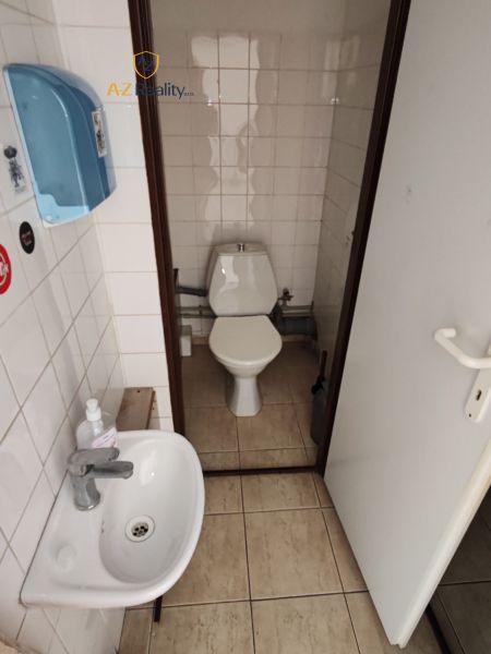 Toilette im Gastronomiebereich mit Waschbecken und Seifenspender.