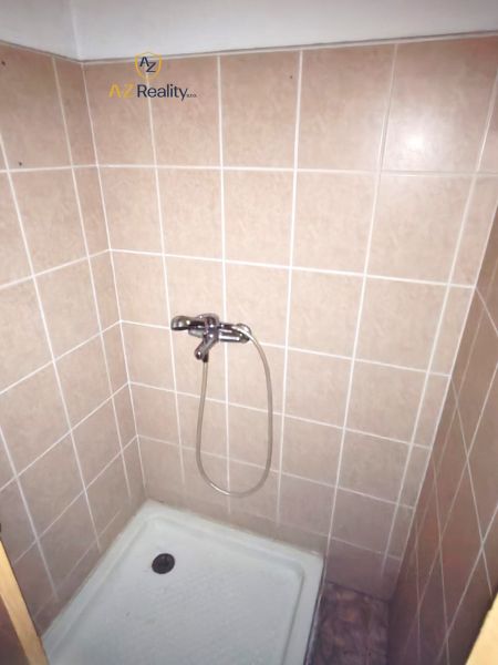 Duschkabine im Badezimmer mit Fliesen in sanften Farbtönen.