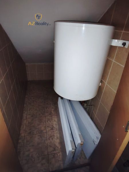 Technikraum im Badezimmer mit Boiler und Heizkörpern auf einem Boden mit Fliesendekor.
