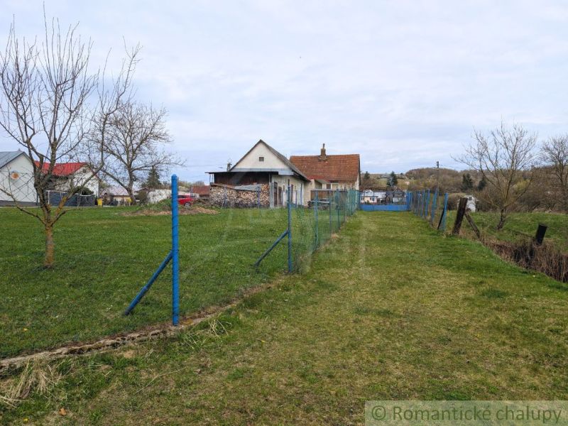 Ein Einfamilienhaus in der Gemeinde Volica mit Rasen und einem blauen Zaun, ohne Laub an den Bäumen.