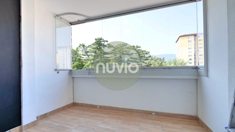 Verglaster Balkon mit Aussicht, 2-Zimmer-Wohnung, Boden mit Holzdekor, angenehmes Licht.