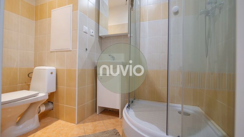 Badezimmer mit Toilette, Duschkabine und Waschbecken in einer 2-Zimmer-Wohnung.