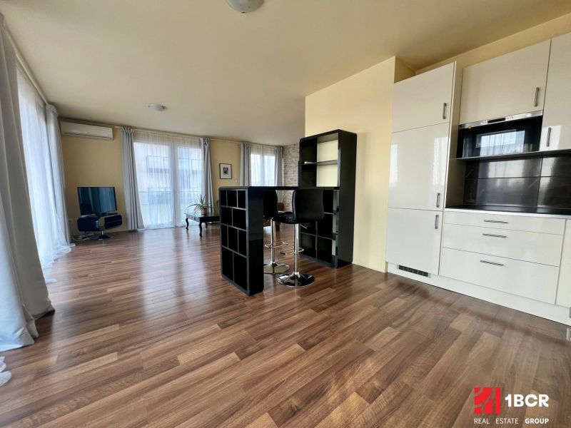 2-Zimmer-Wohnung mit Holzboden und weißer Küchenzeile.