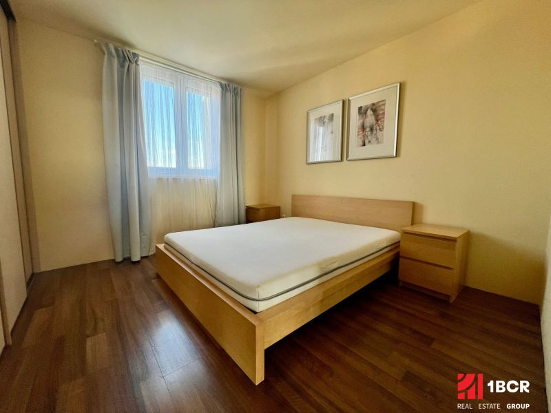 Schlafzimmer in einer 2-Zimmer-Wohnung mit einem Bett und einem Boden in Holzoptik.