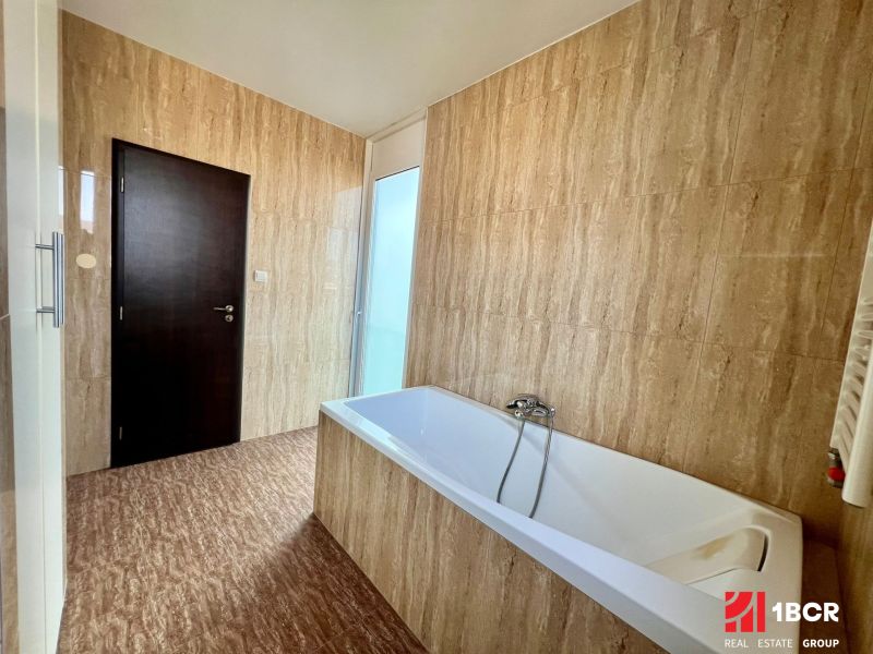 Badezimmer mit Badewanne und Fliesen in einer 2-Zimmer-Wohnung.
