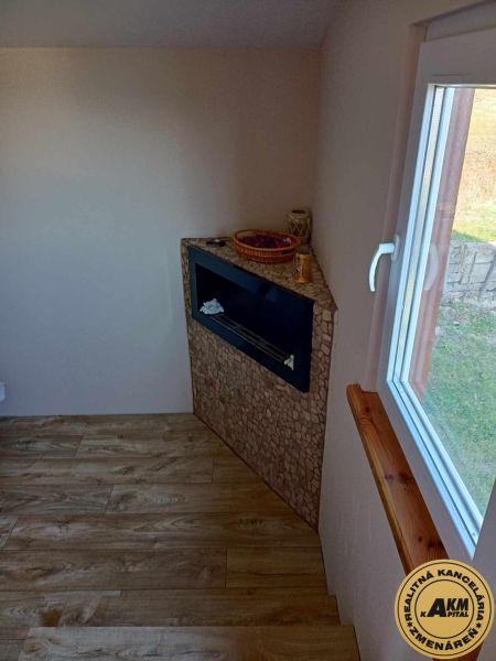 Innenraum mit Wandkamin, dekorativer Verkleidung und Boden mit Holzdekor.