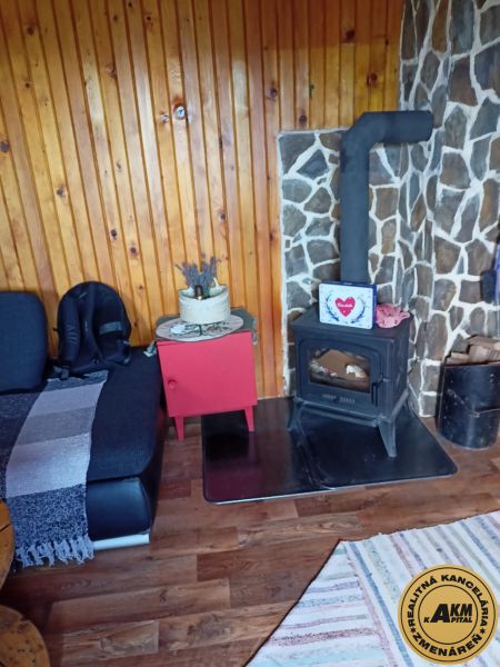 Ein Interieur mit einem antiken Kamin, einem Boden in Holzoptik und einer Ruhe-Ecke.