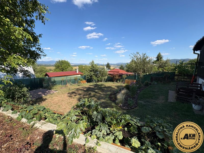 Ein Garten in Zvolen mit Blick auf die Hügel, einem Rasen und einem Pavillon unter blauem Himmel.